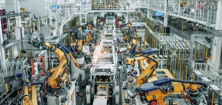 Фотография демонстрирует сборочный конвейер автомобильного завода, на котором частично приостановлена работа.