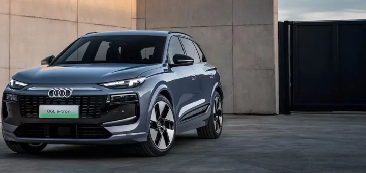 Новый электрический кроссовер Audi Q6L e-tron на фоне городского пейзажа