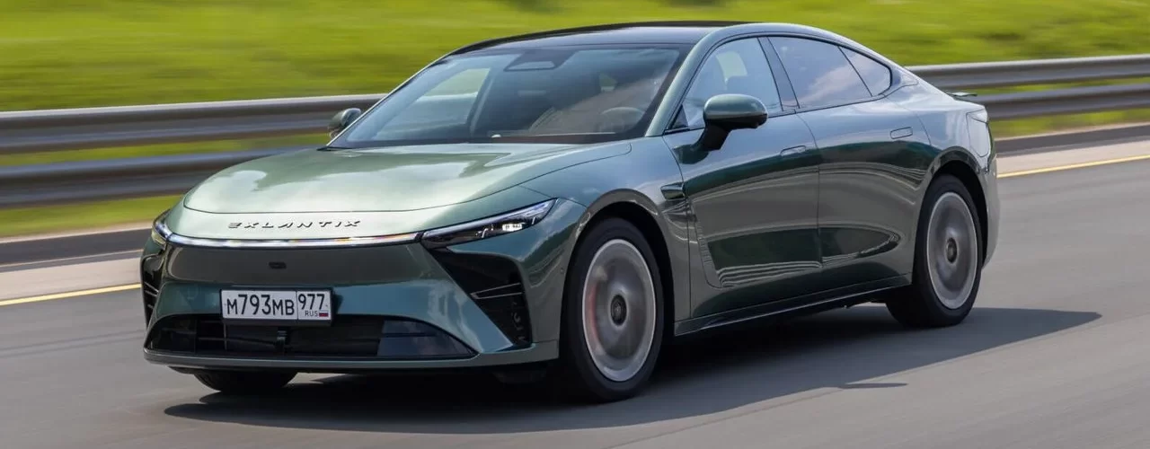 Спортивное гибридное купе Exlantix ES серебристого цвета на фоне городского пейзажа.