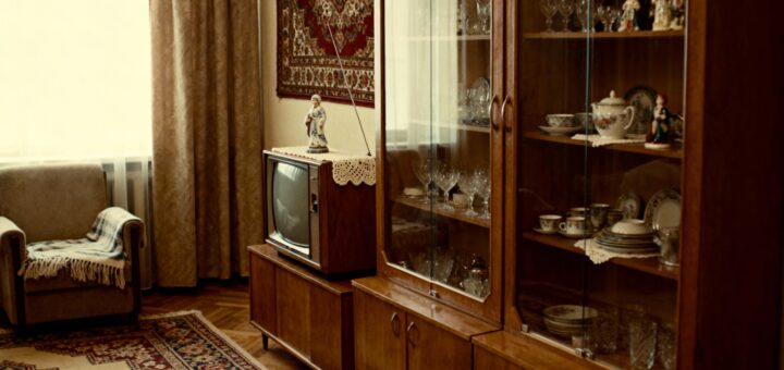 Интерьер типичной советской гостиной с ковром на стене и массивной стенкой